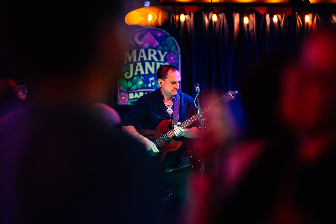 a man playing a guitar in a bar