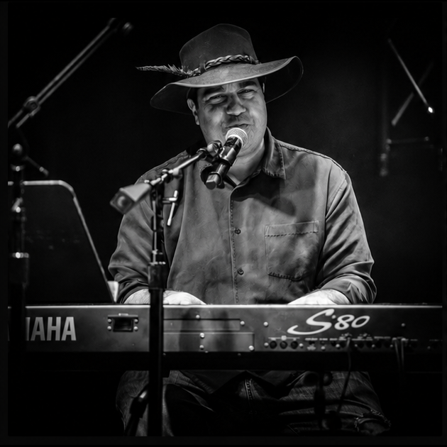 a man in a hat playing a keyboard
