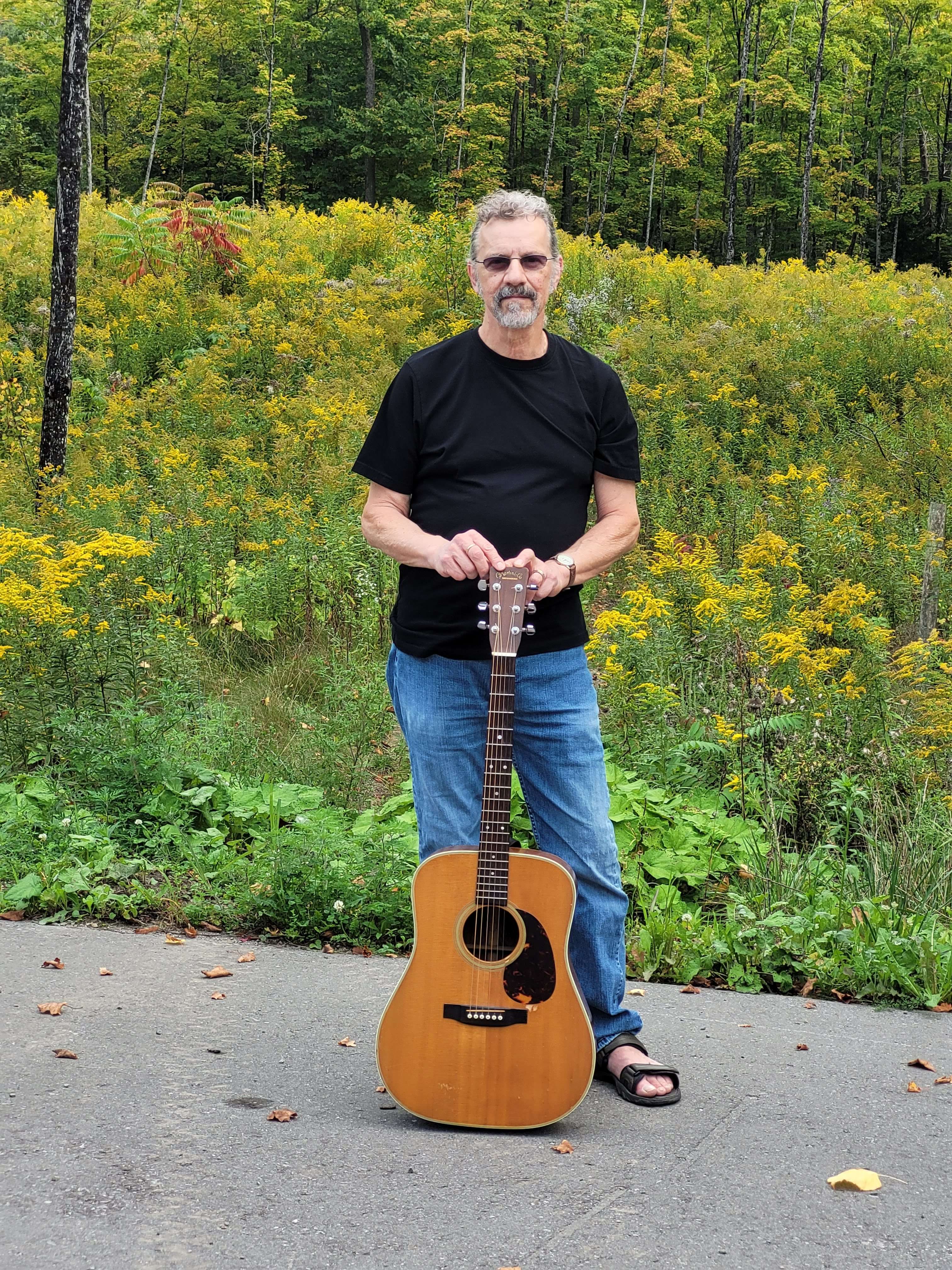 a man holding an acoustic guitar