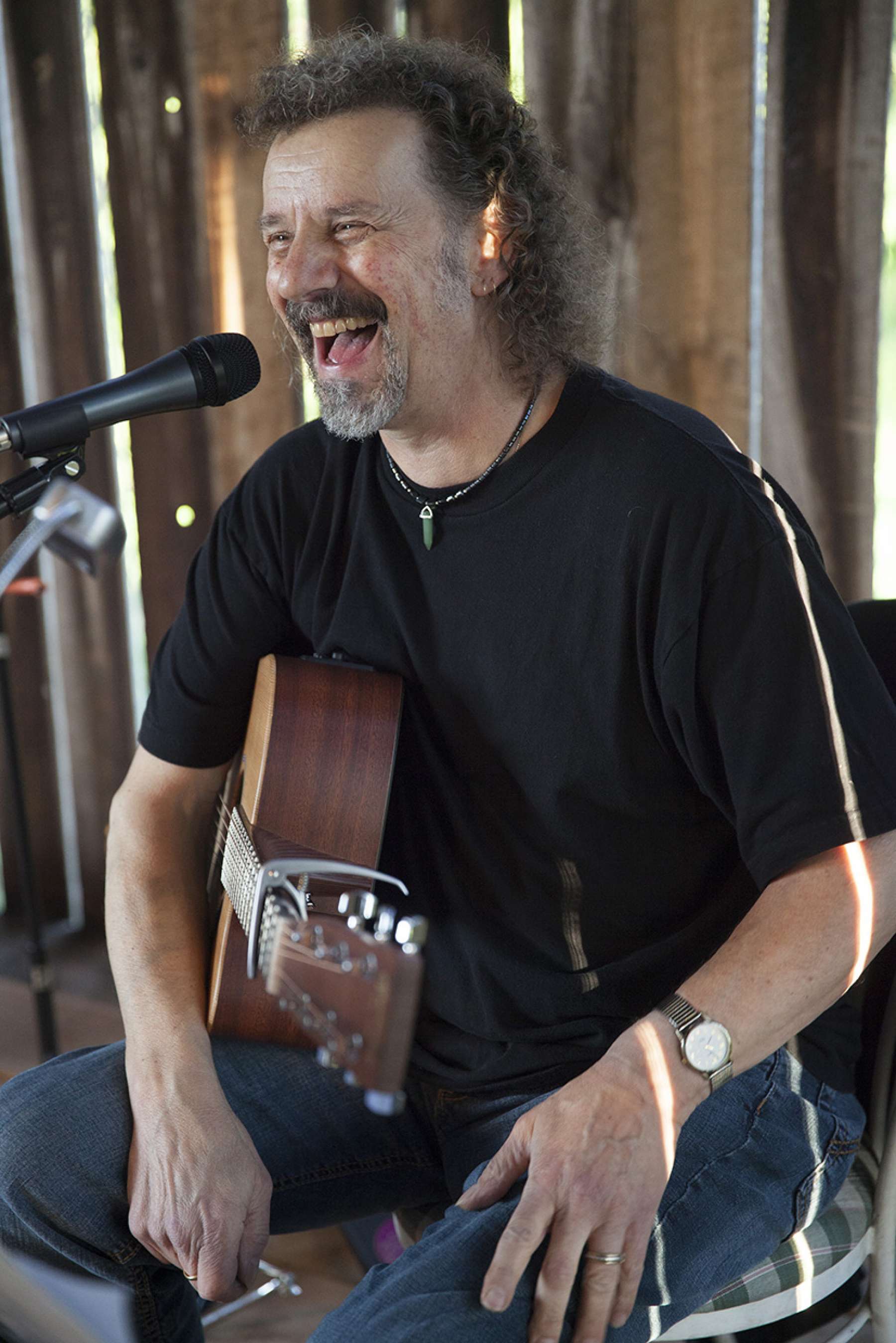 a man sitting in a chair with an acoustic guitar