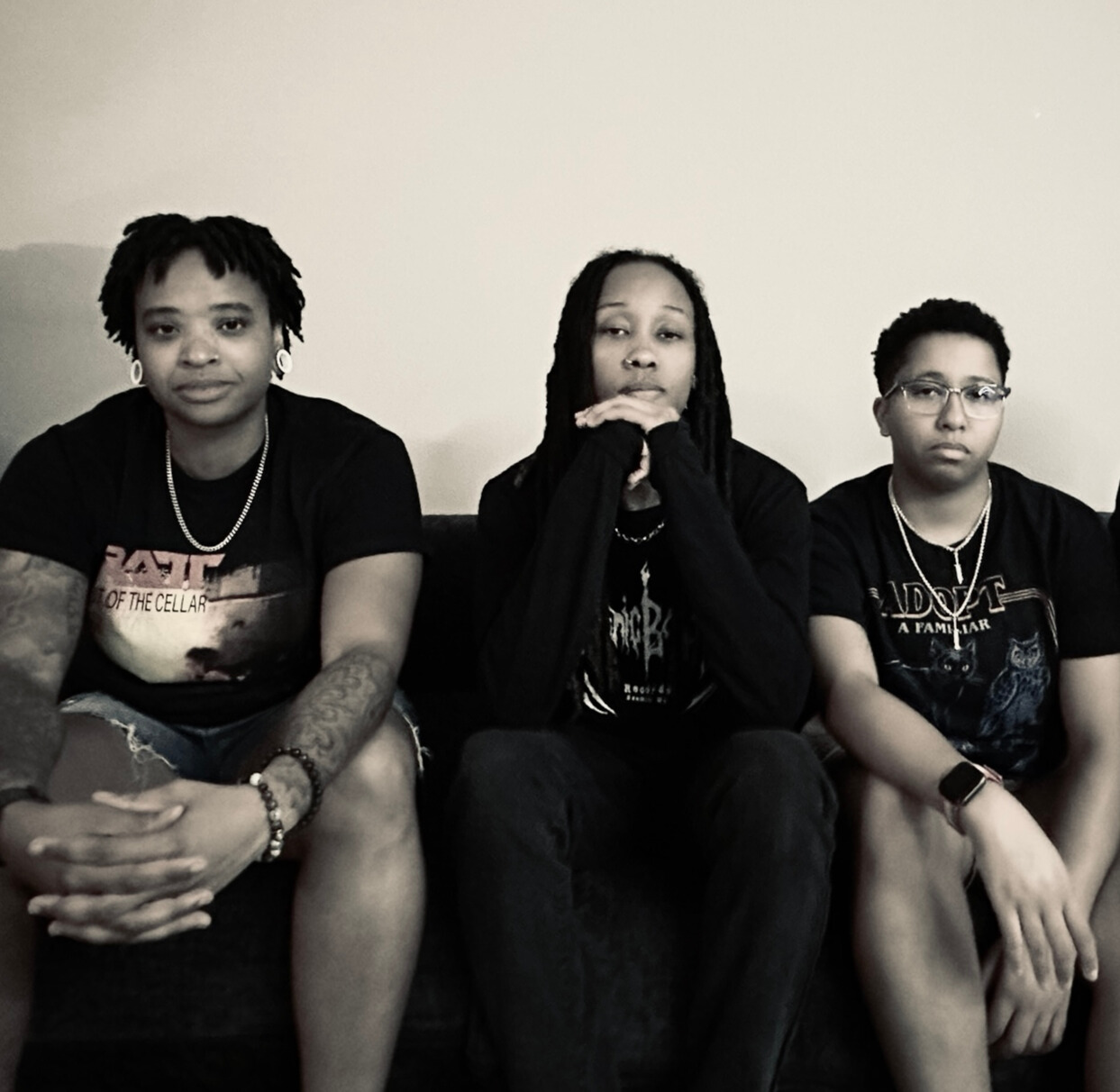 a black and white photo of a group of young people sitting on a couch