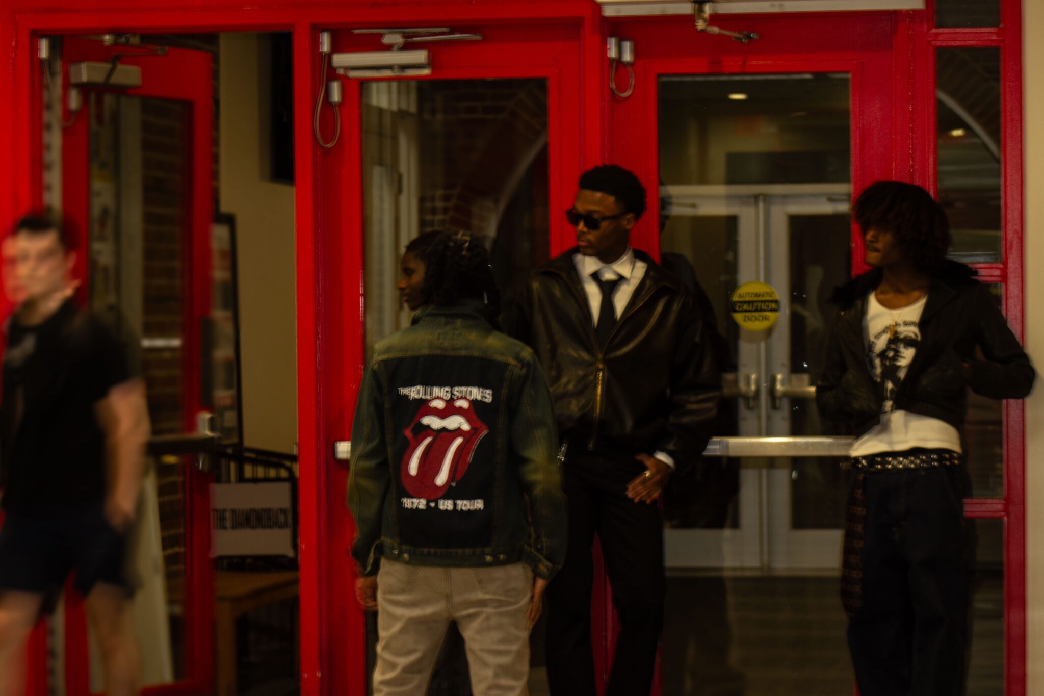 a group of people standing in front of a red door