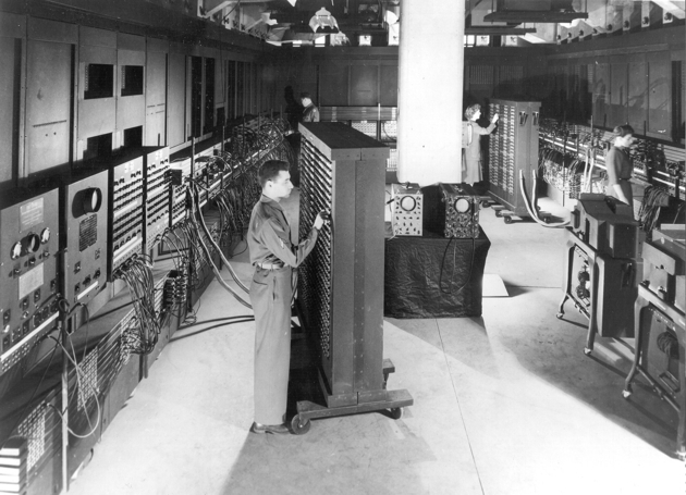 an old photo of a man working in a room full of electronic equipment