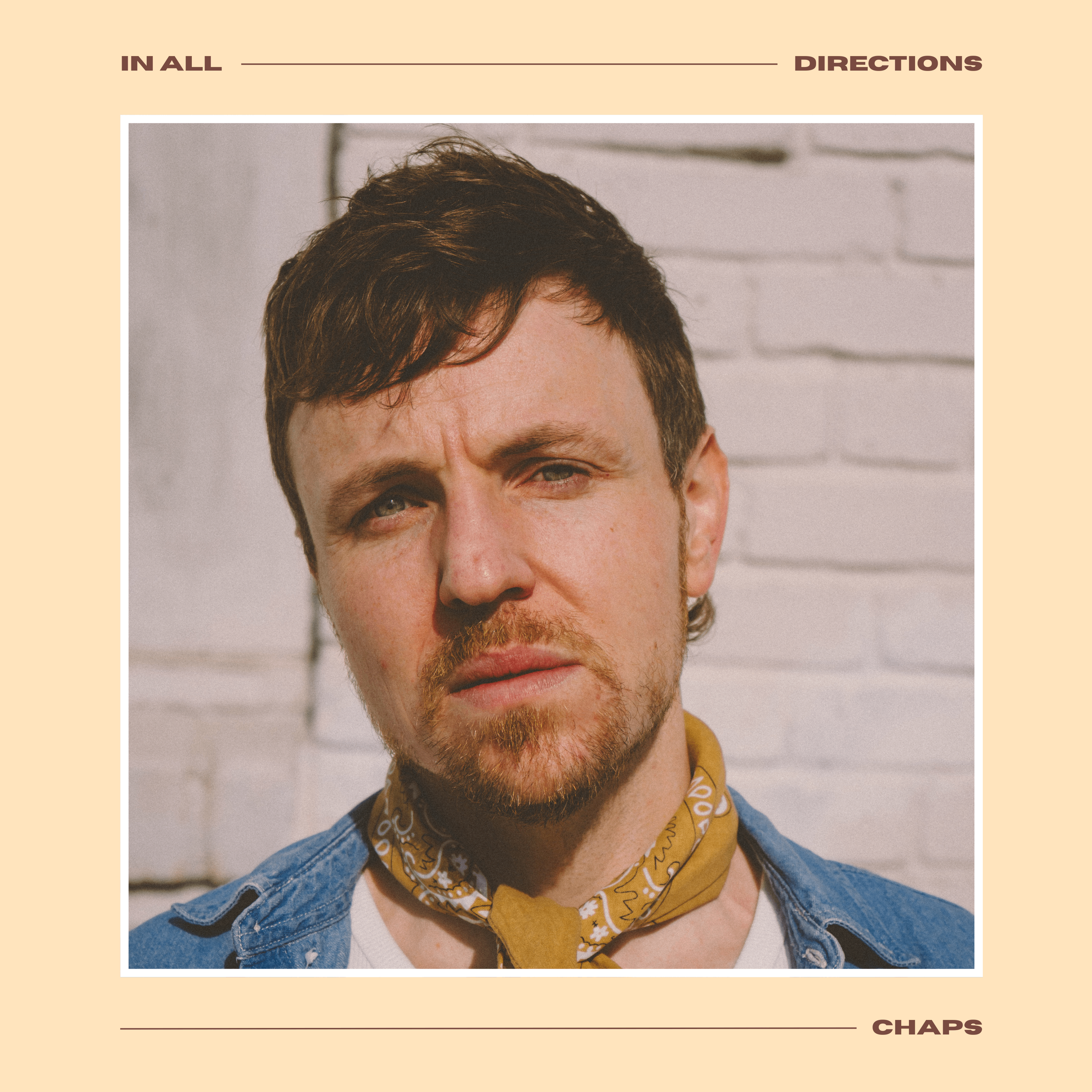 CHAPS - IN ALL DIRECTIONS: a man wearing a bandana is standing in front of a brick wall