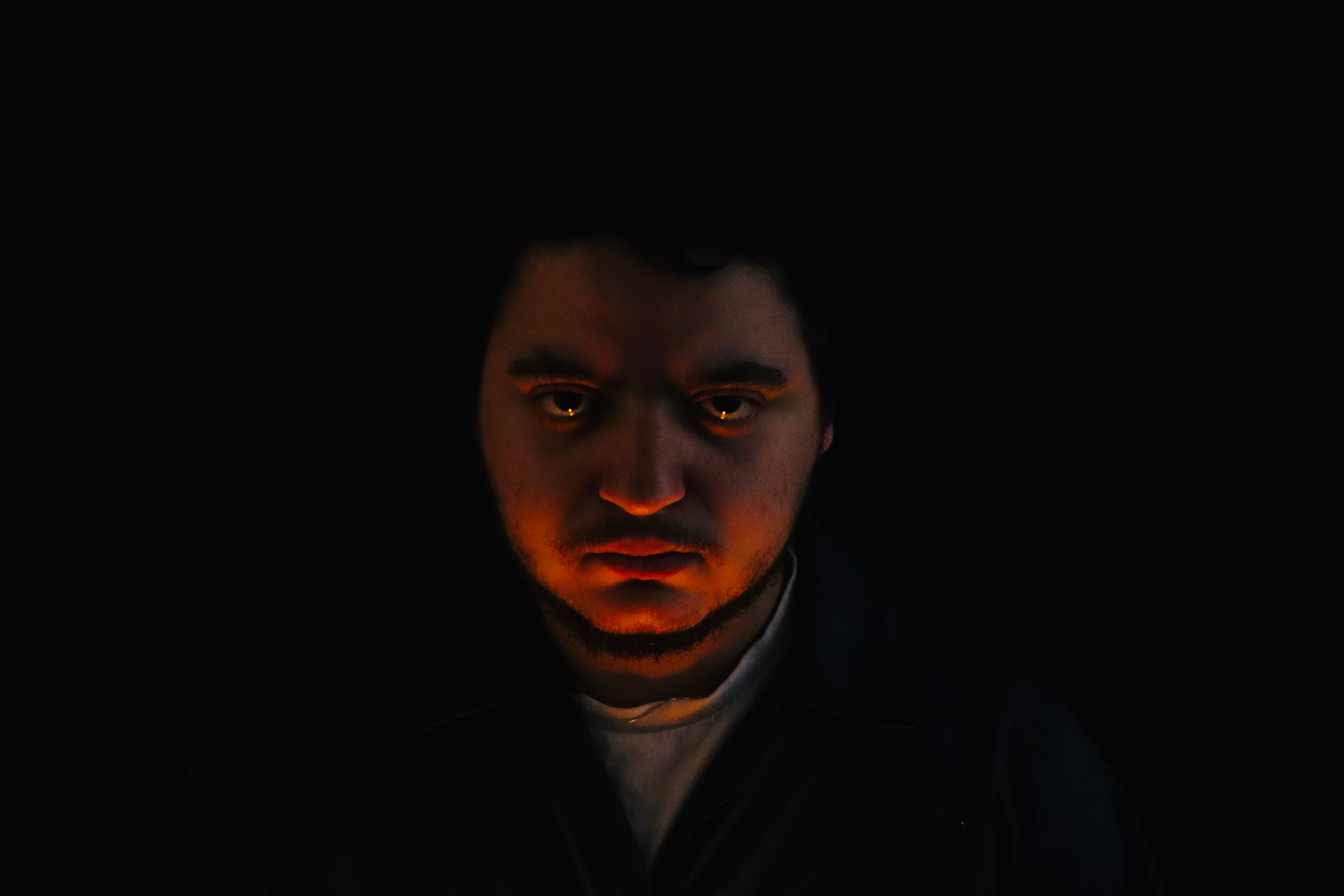 a man in a dark room with a candle in his hand