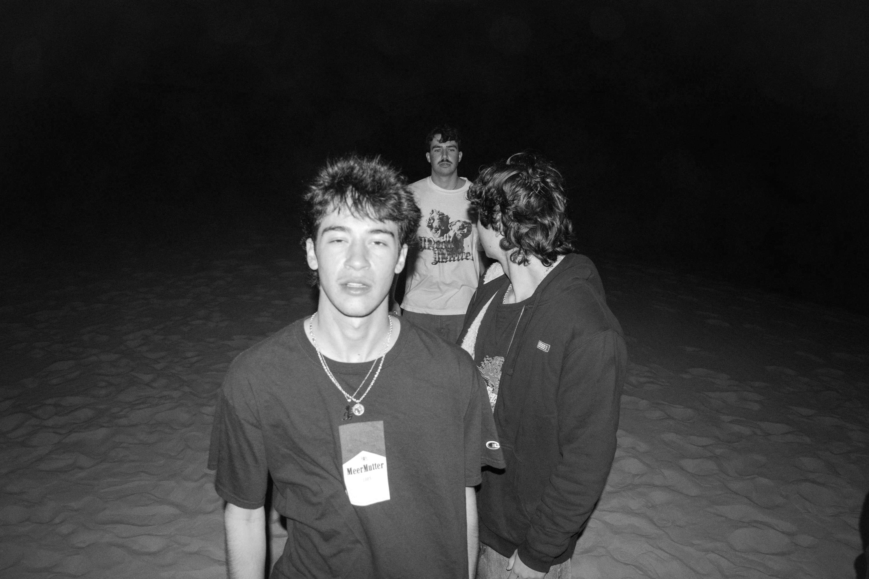a black and white photo of a group of people on the beach