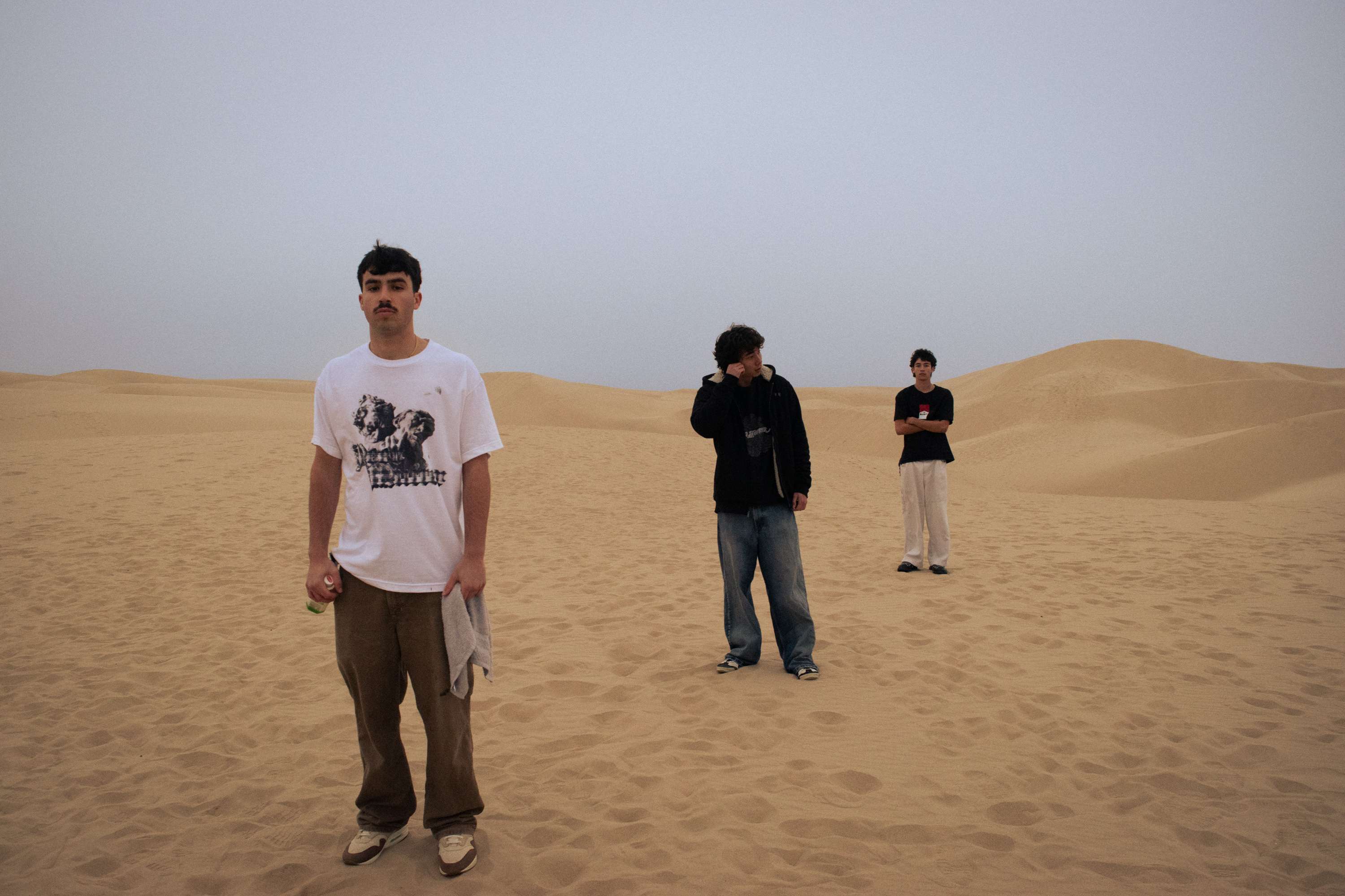 a group of people standing in the sand