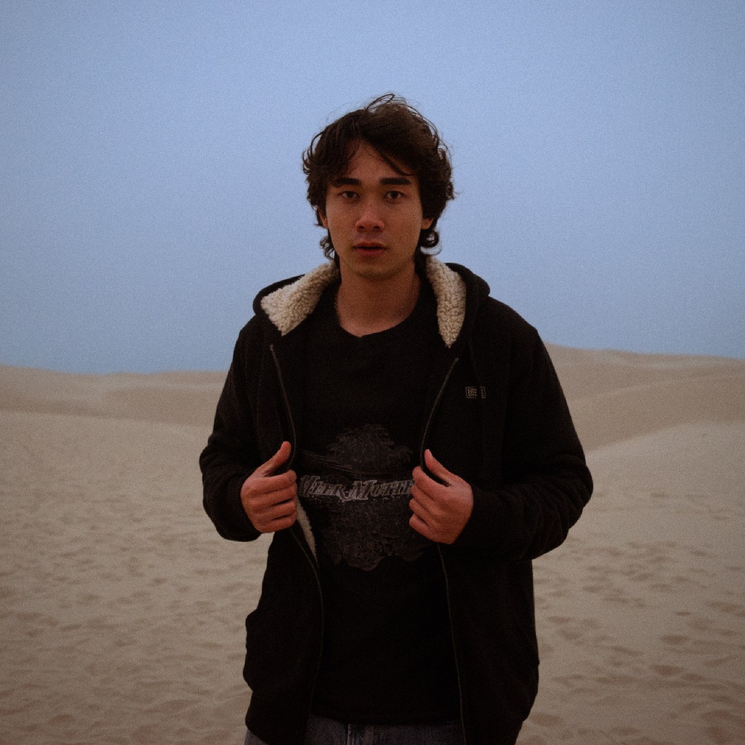 a young man standing in a desert