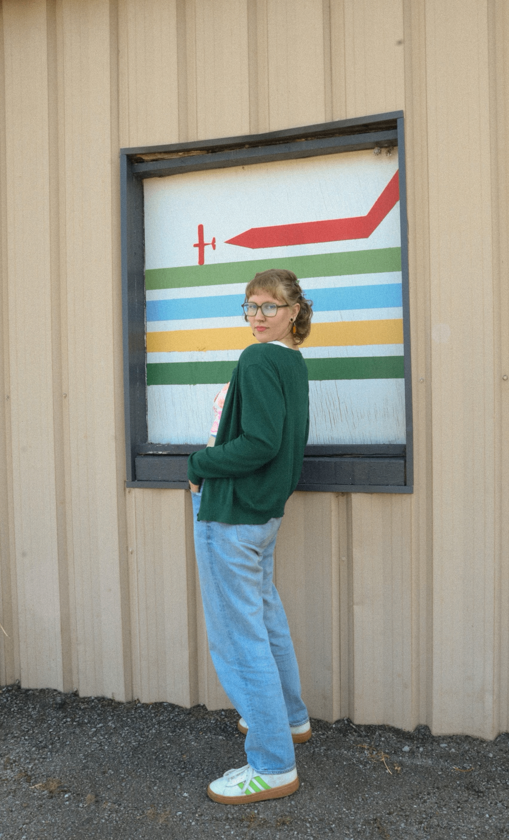 a woman standing in front of a building with a sign