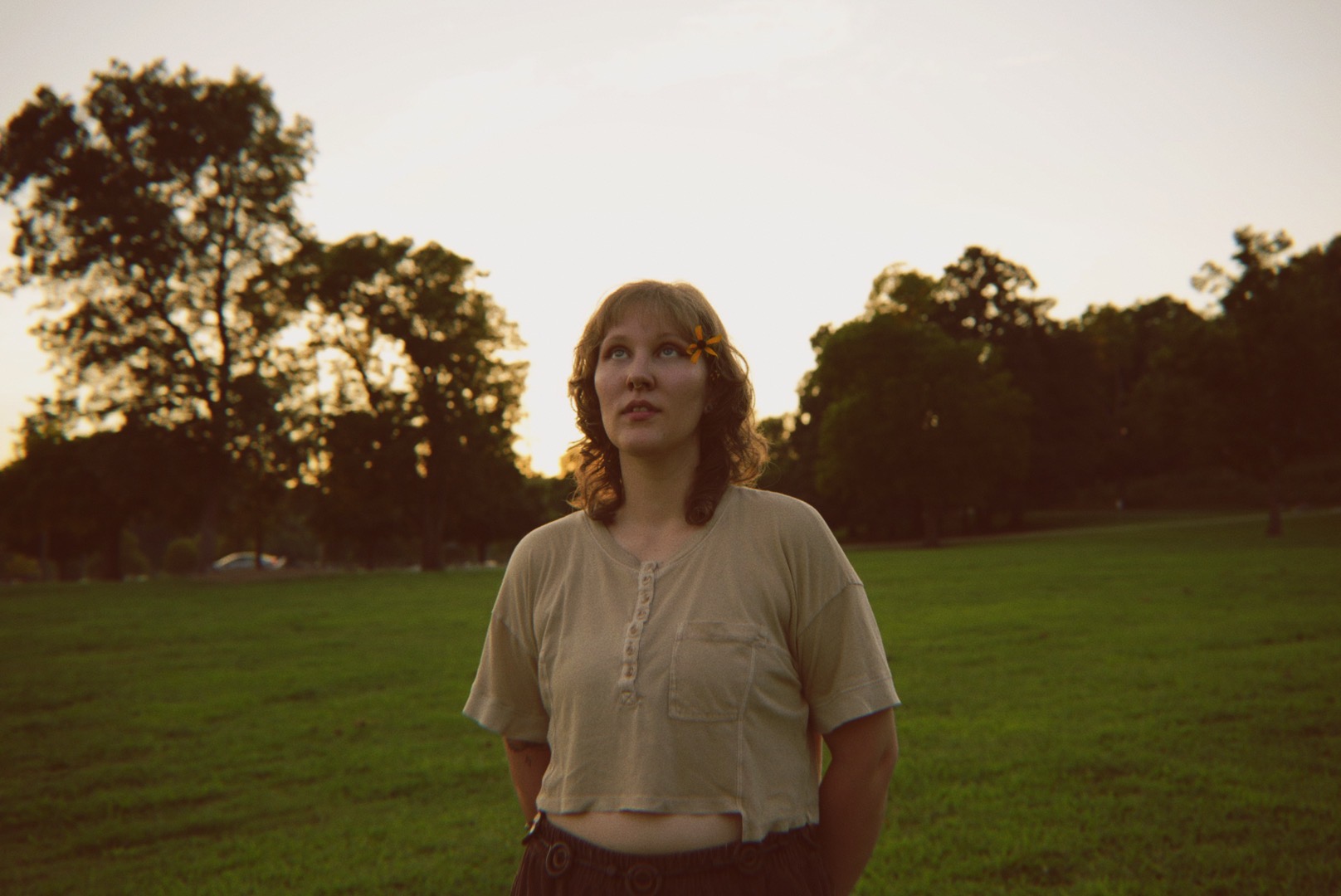 a woman standing in a field with a frisbee