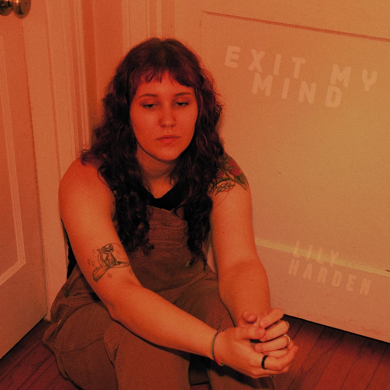 a woman with tattoos sitting on the floor