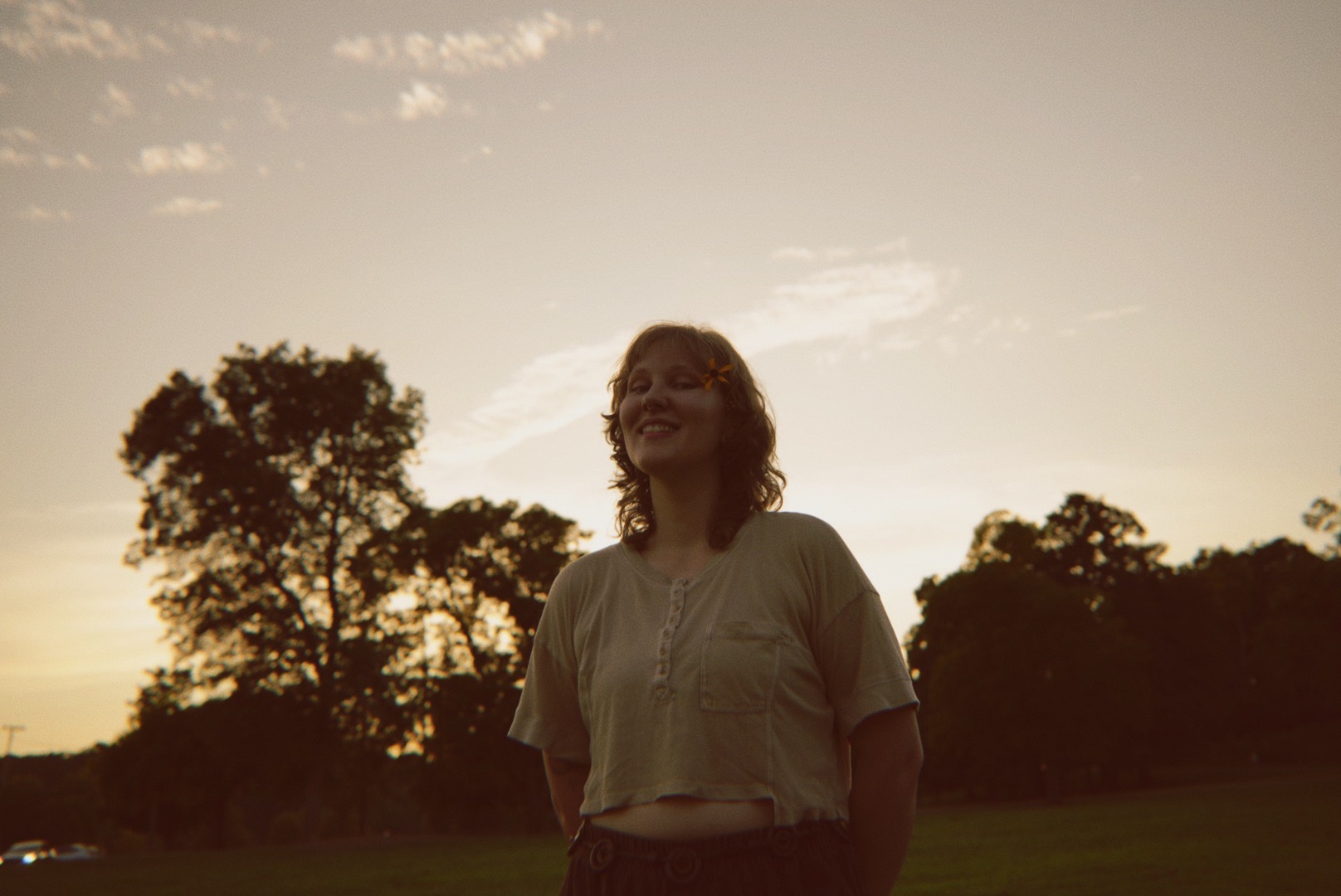 a woman standing in a field with a frisbee