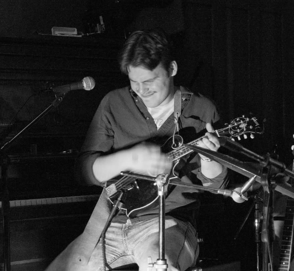 a man playing a banjo in front of a microphone