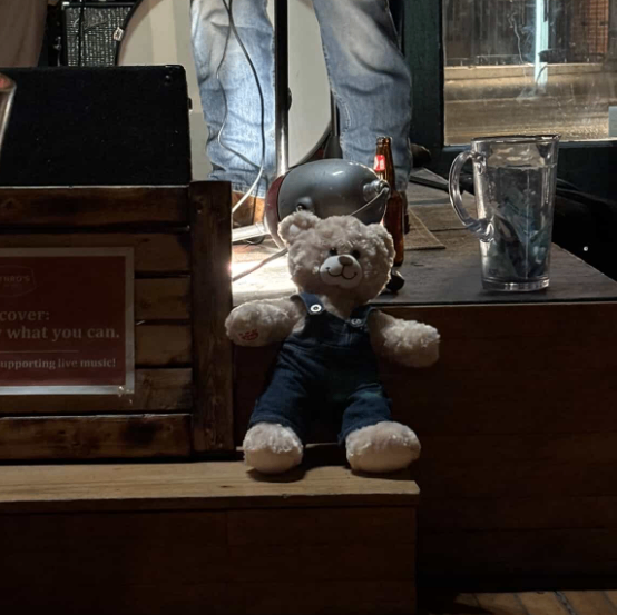 a teddy bear sitting on a wooden bench