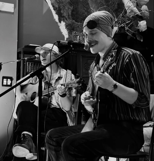 a black and white photo of a group of people sitting in front of a microphone