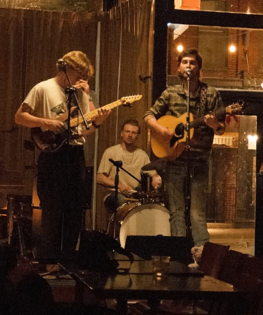 a group of people playing music in a bar