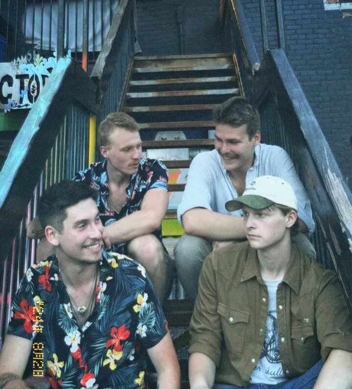 a group of young men sitting on a set of stairs