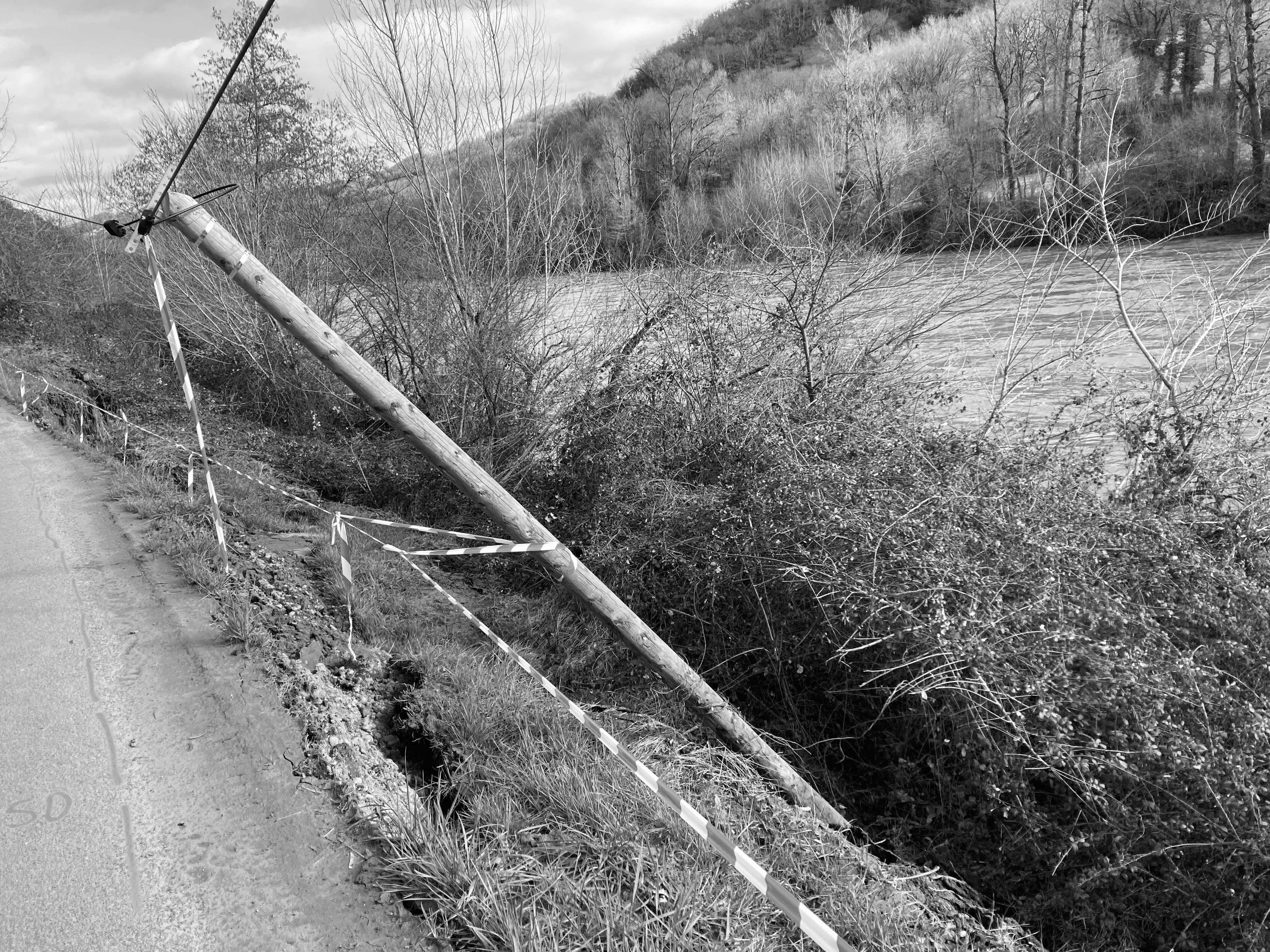 a black and white photo of a road near a river