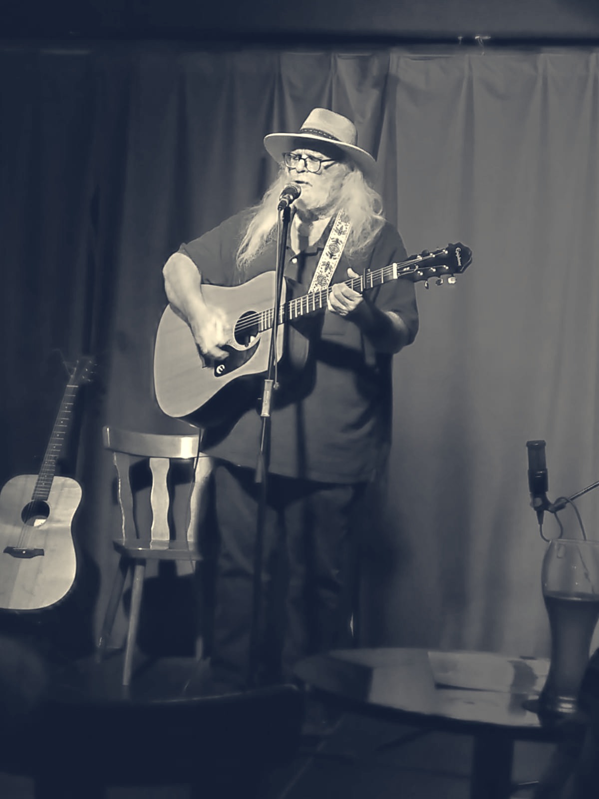 a man in a hat playing an acoustic guitar