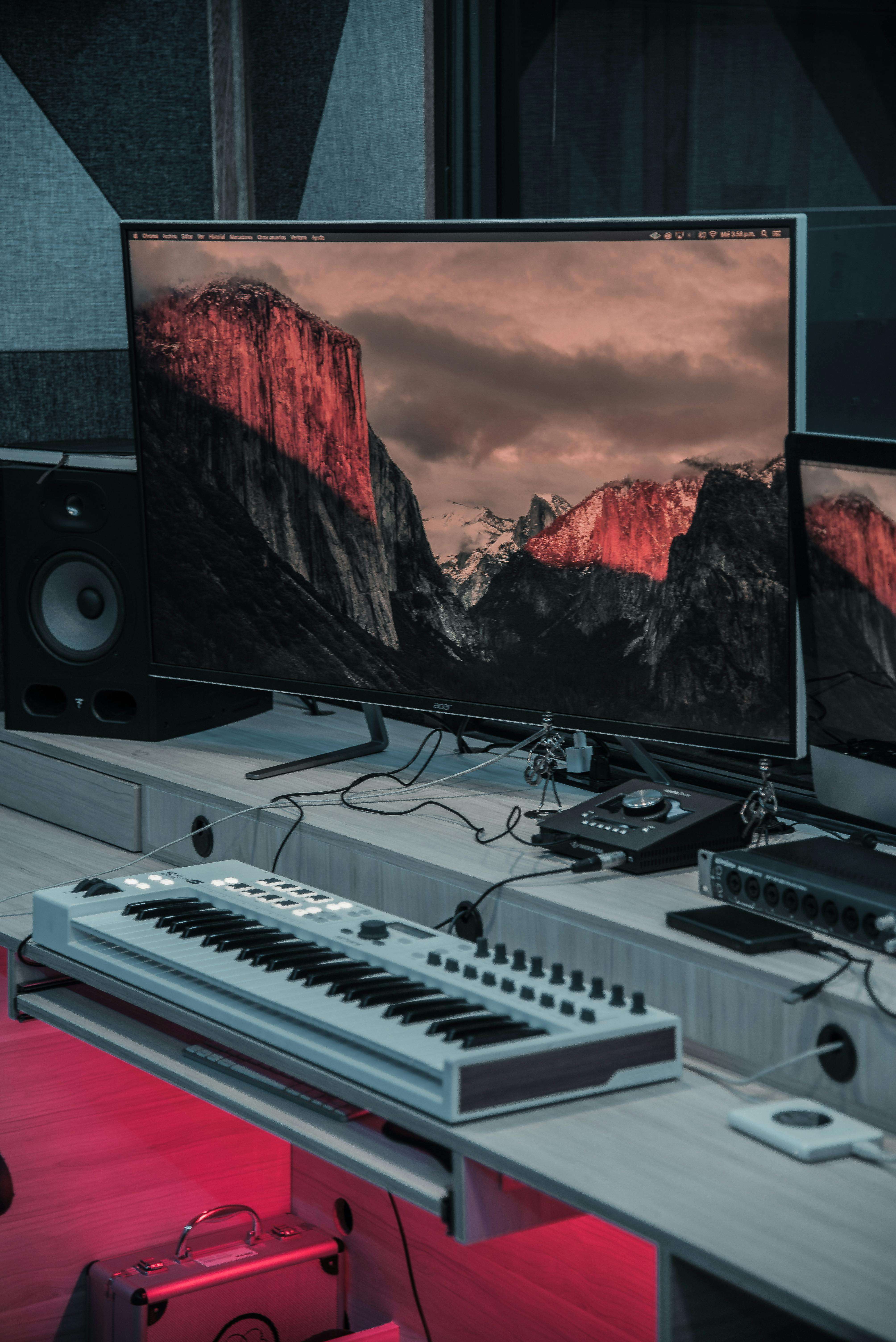 a recording studio with two monitors and a keyboard