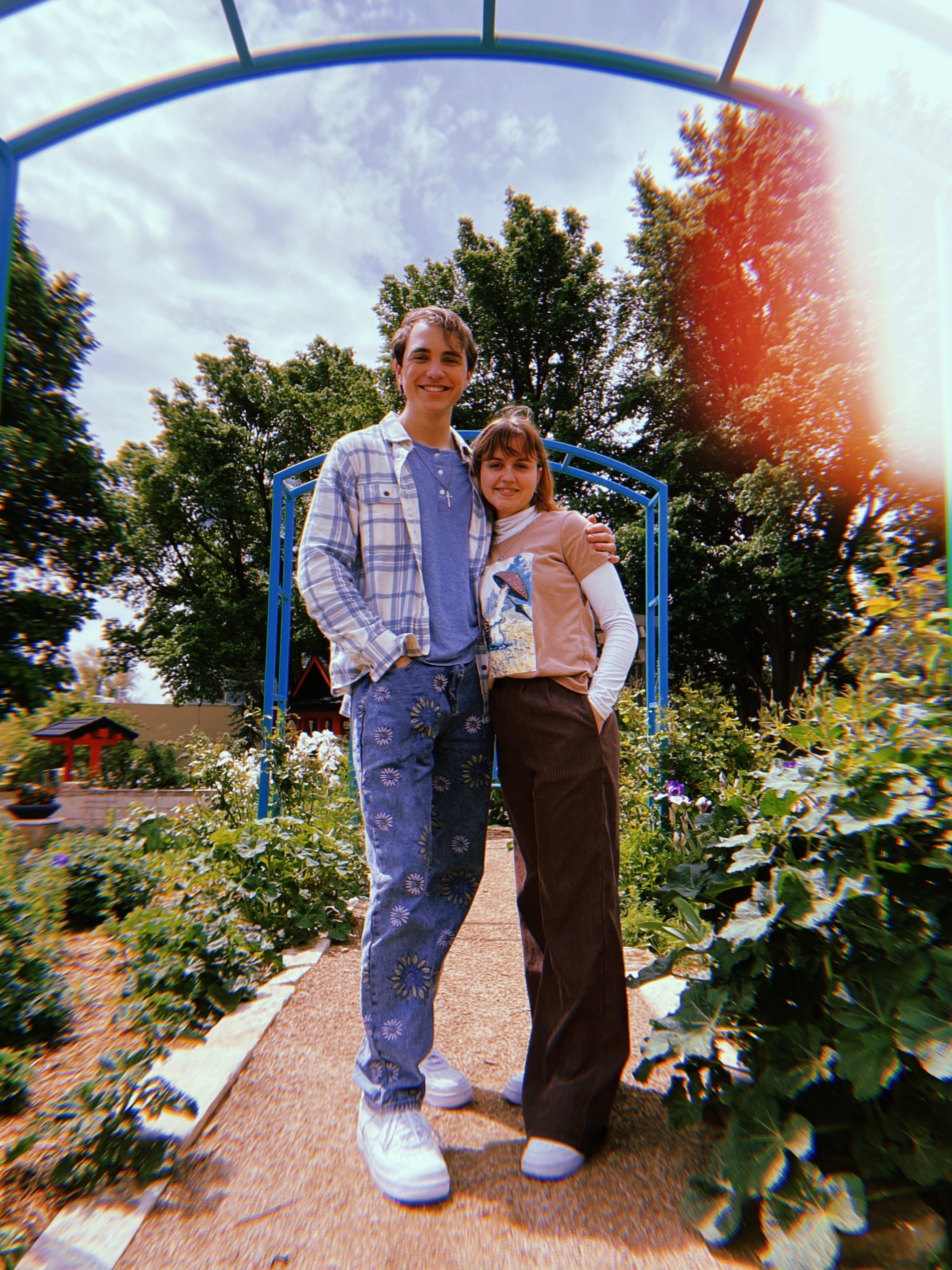 a man and a woman posing for a picture in a garden