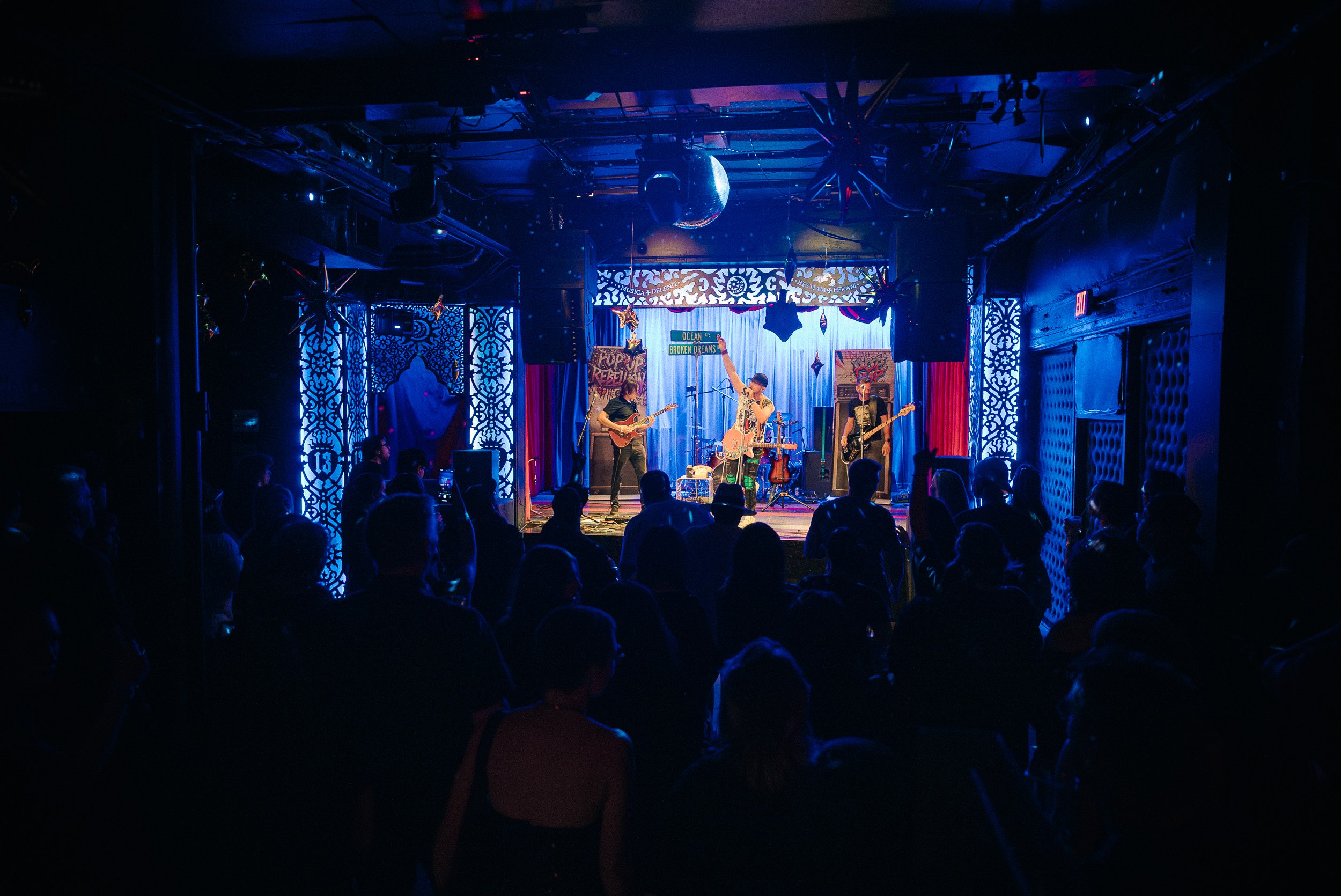 a crowd of people watching a band perform in a dark room