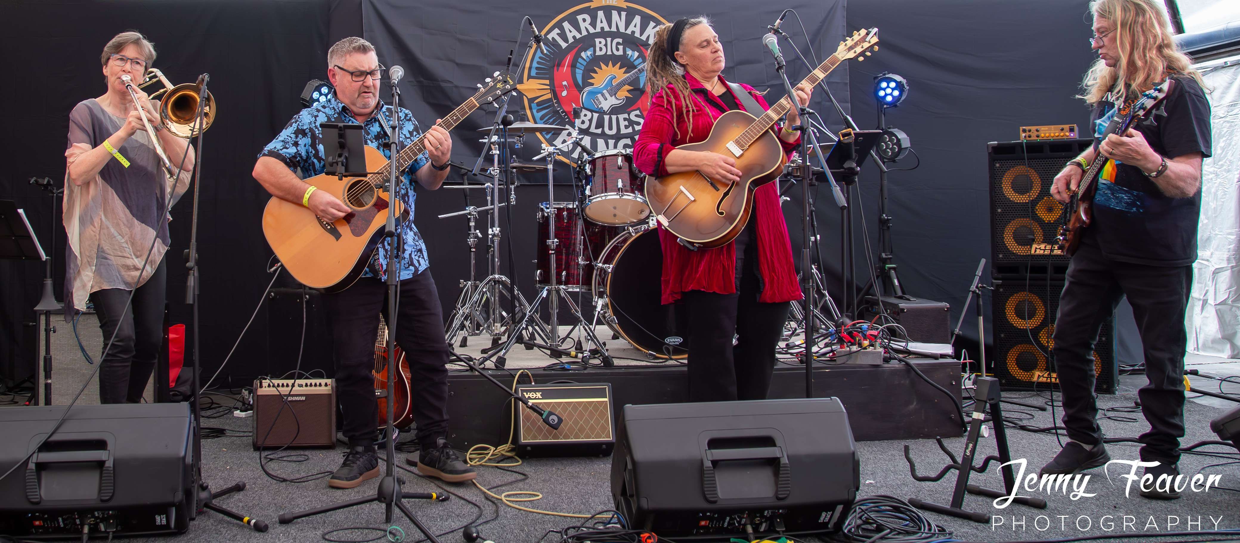 a group of people playing music on stage at a festival