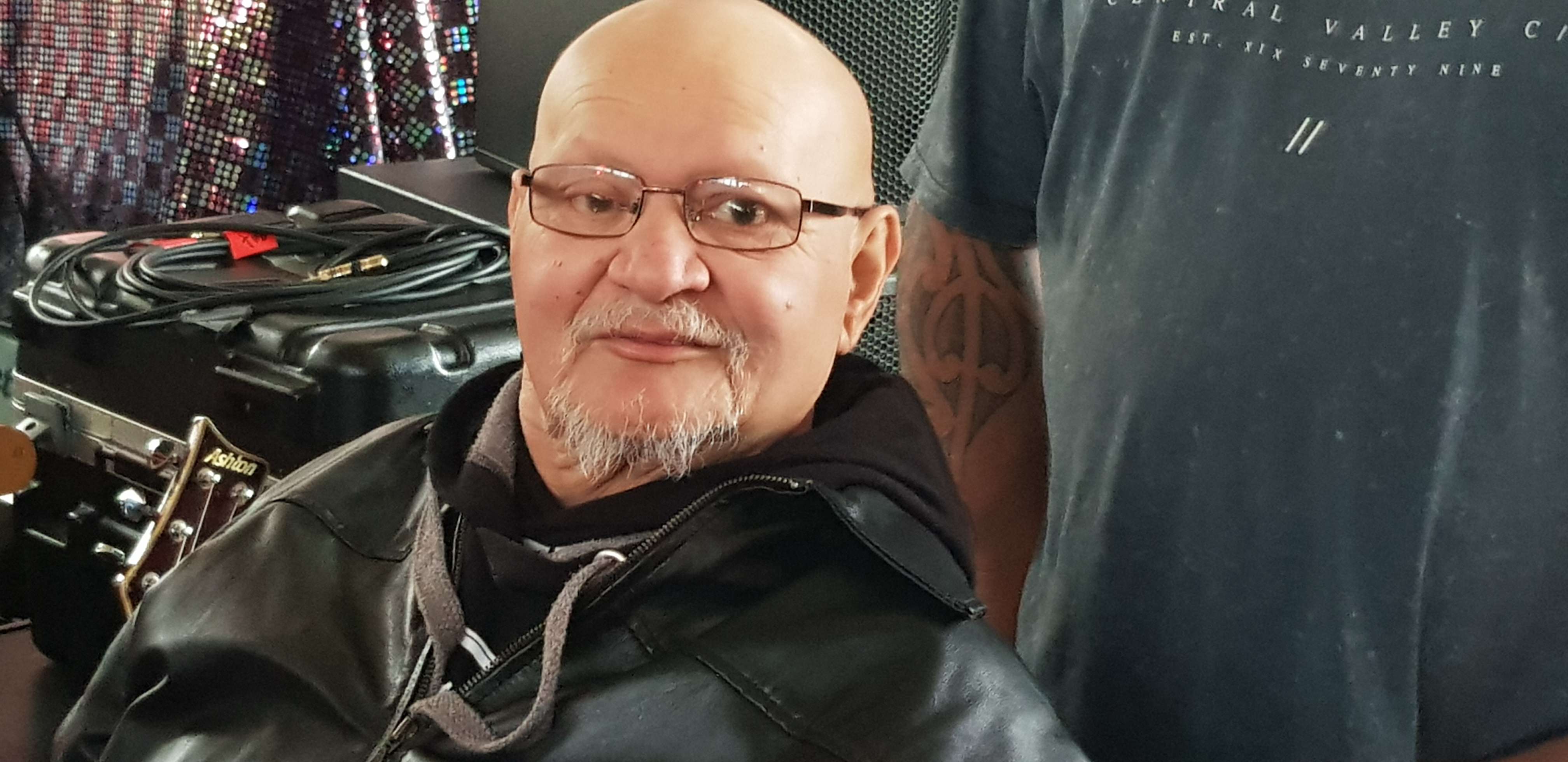 a bald man with glasses is sitting in a barber shop