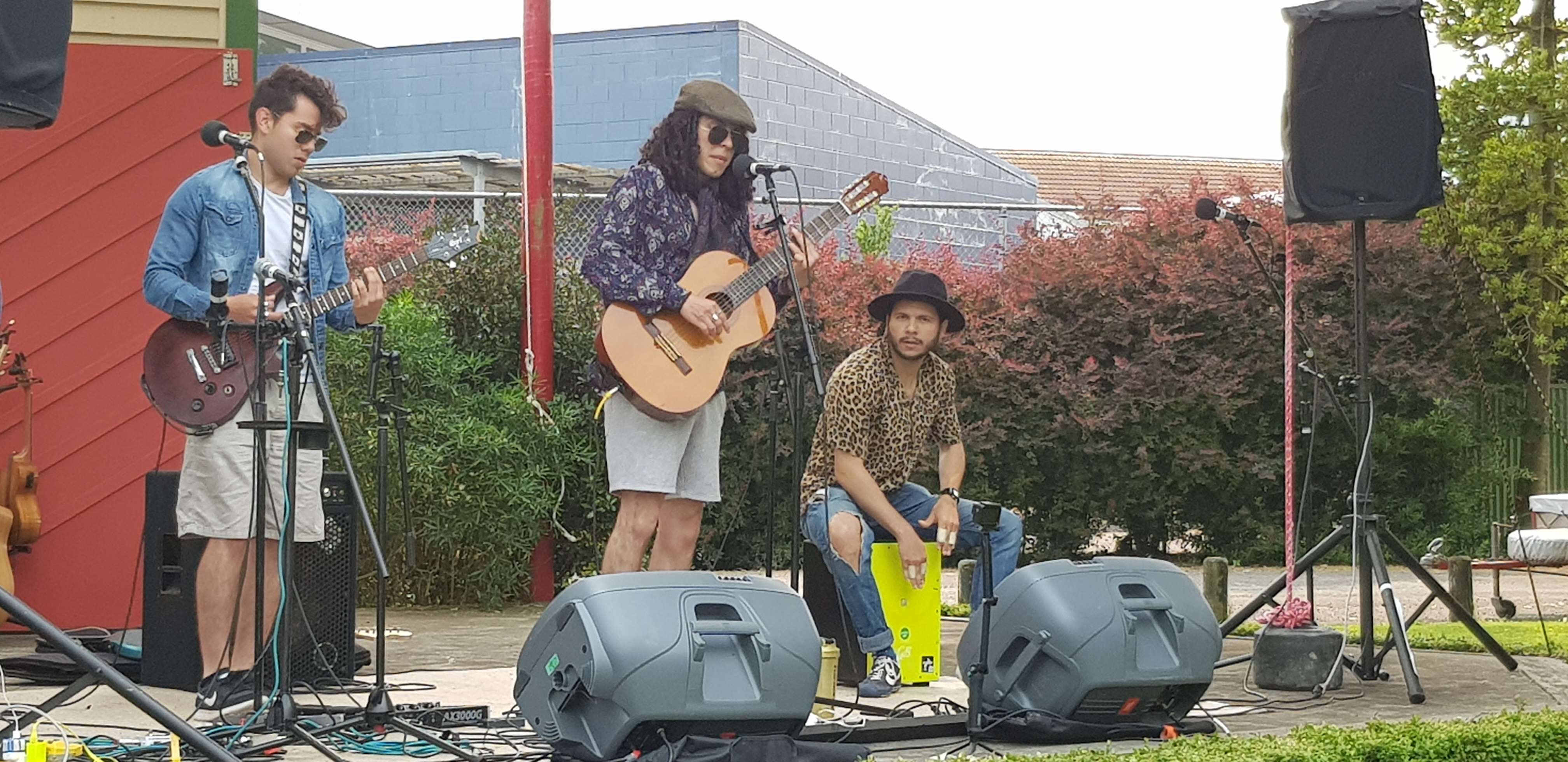 a group of people playing music on a stage in front of a building