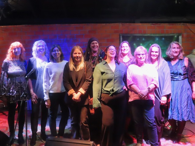 a group of women standing in front of a stage
