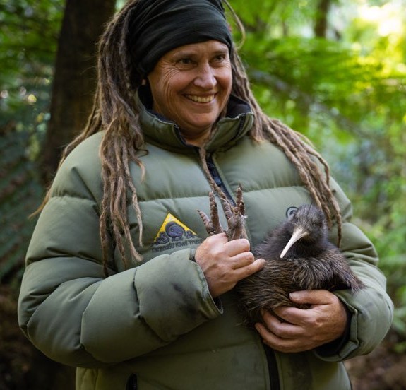 a woman with dreadlocks holding a baby kiwi