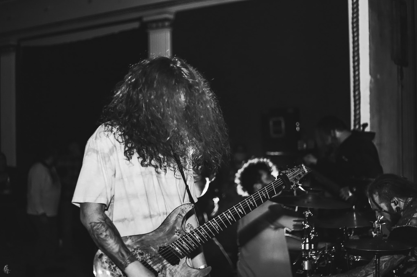 a black and white photo of a man playing an electric guitar