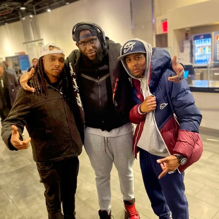 three men posing for a picture in an airport
