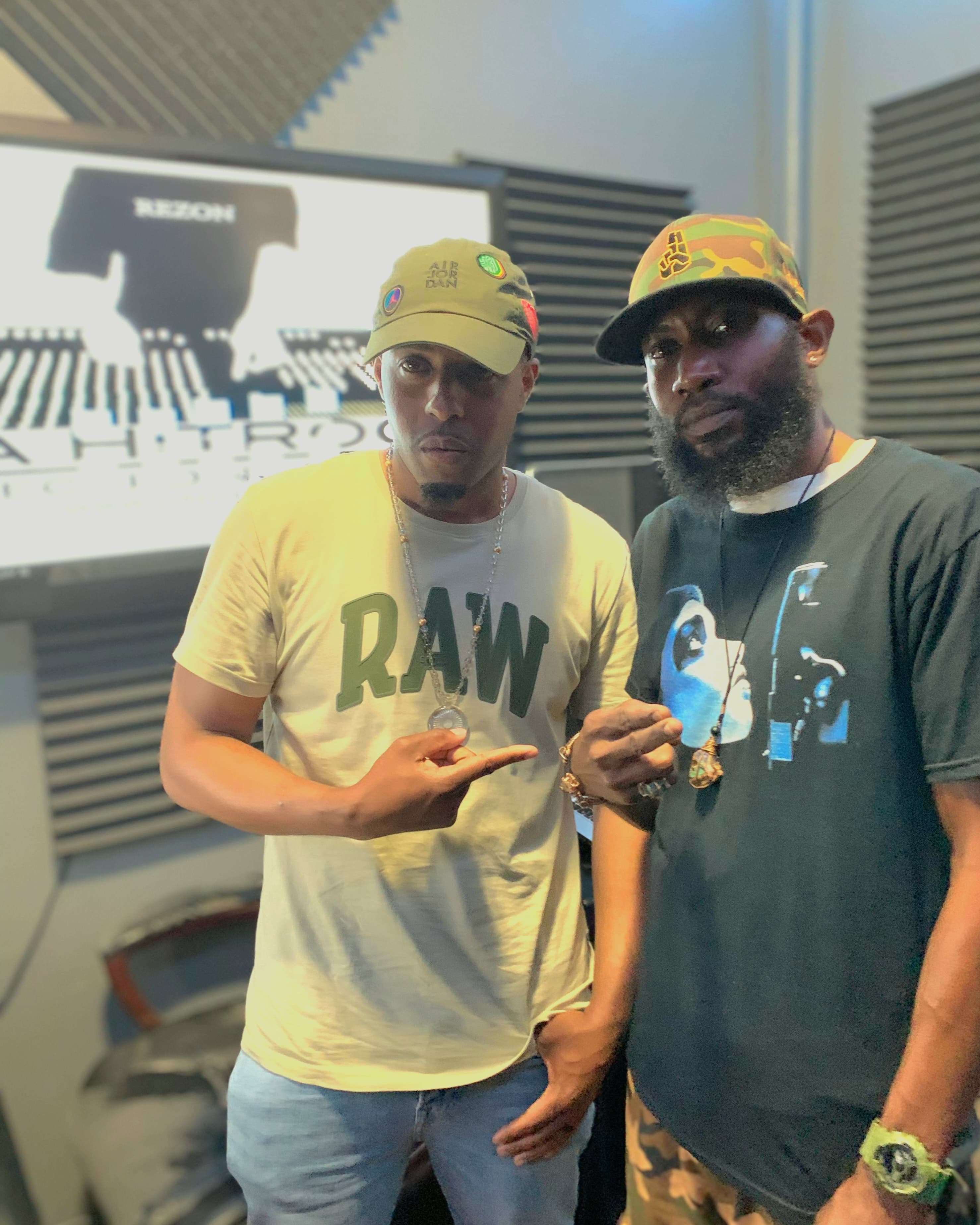 two men standing next to each other in a recording studio