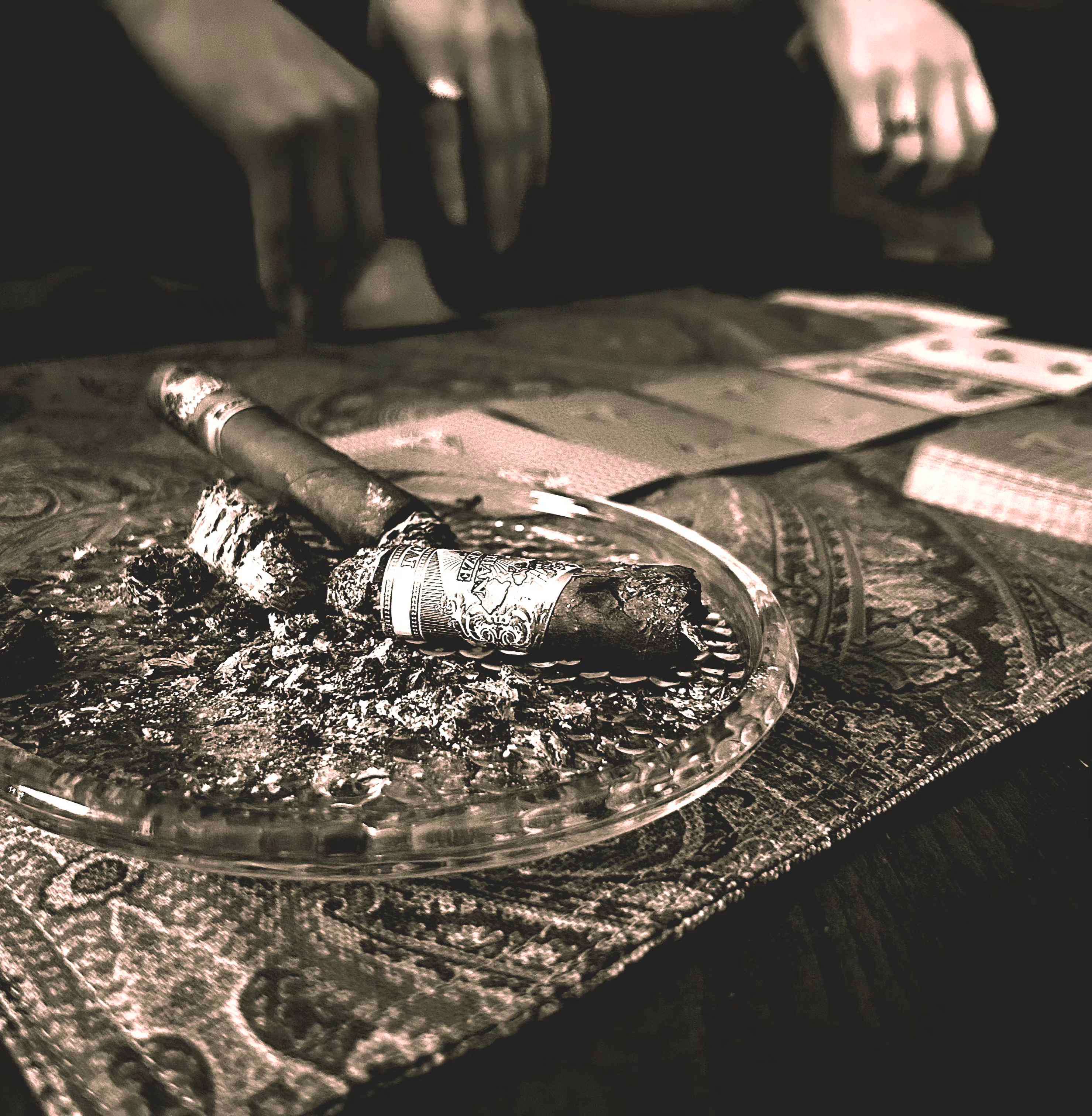 Superimposed - Cigar: a person holding a cigar on a table