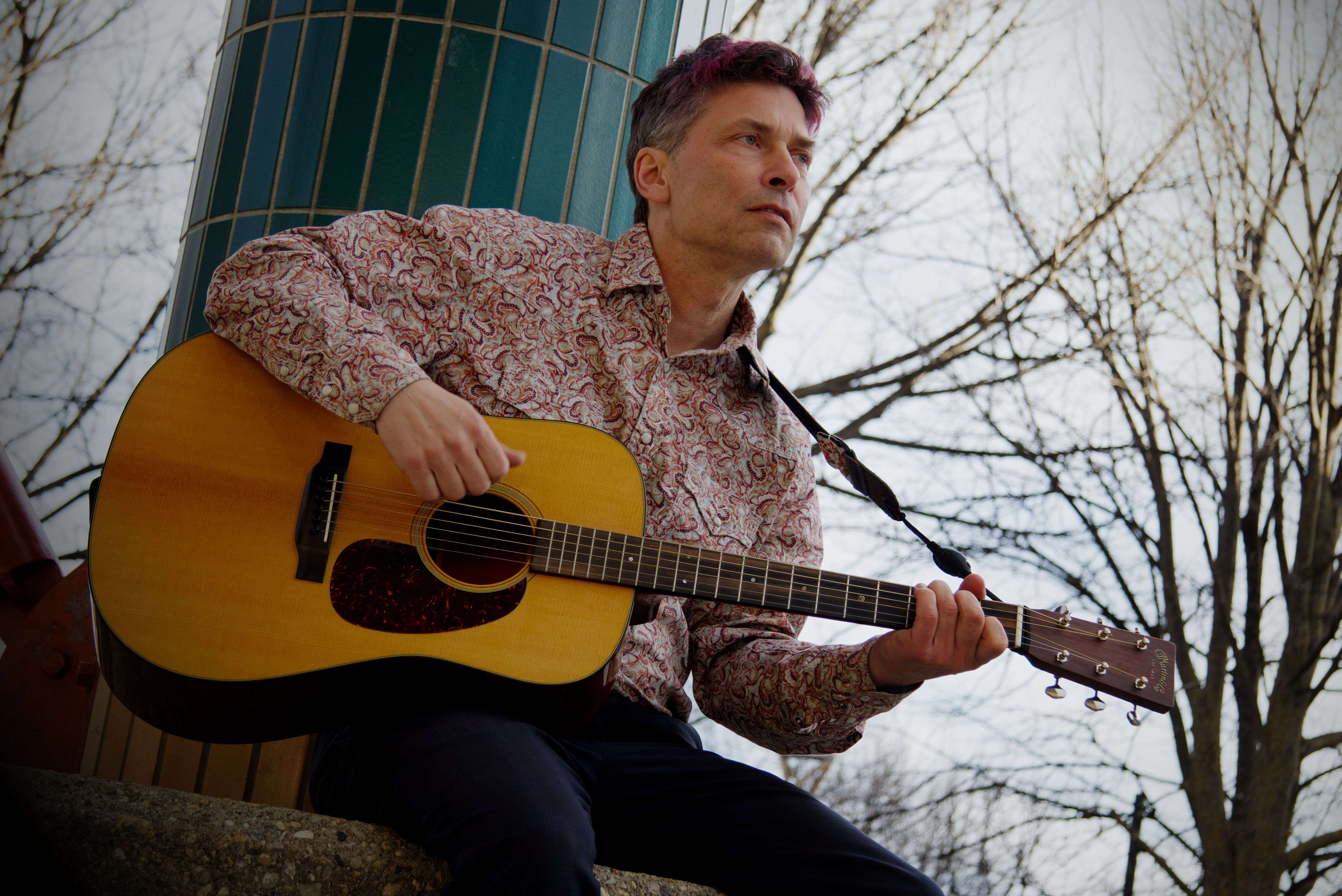 a man playing an acoustic guitar