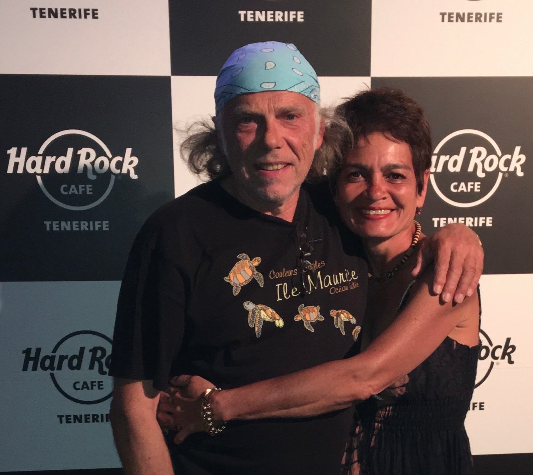a man and woman posing for a photo at a hard rock cafe