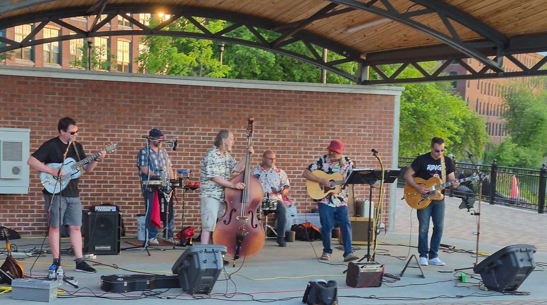 a group of people playing music on a stage in front of a brick wall