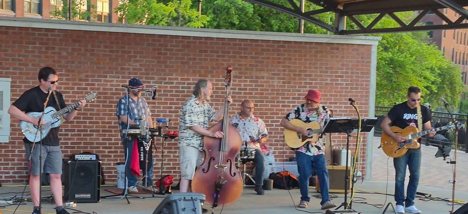 a group of people playing music in front of a brick wall
