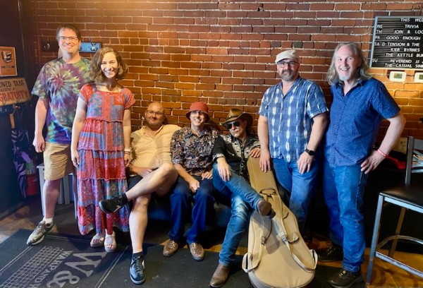 a group of people posing in front of a brick wall