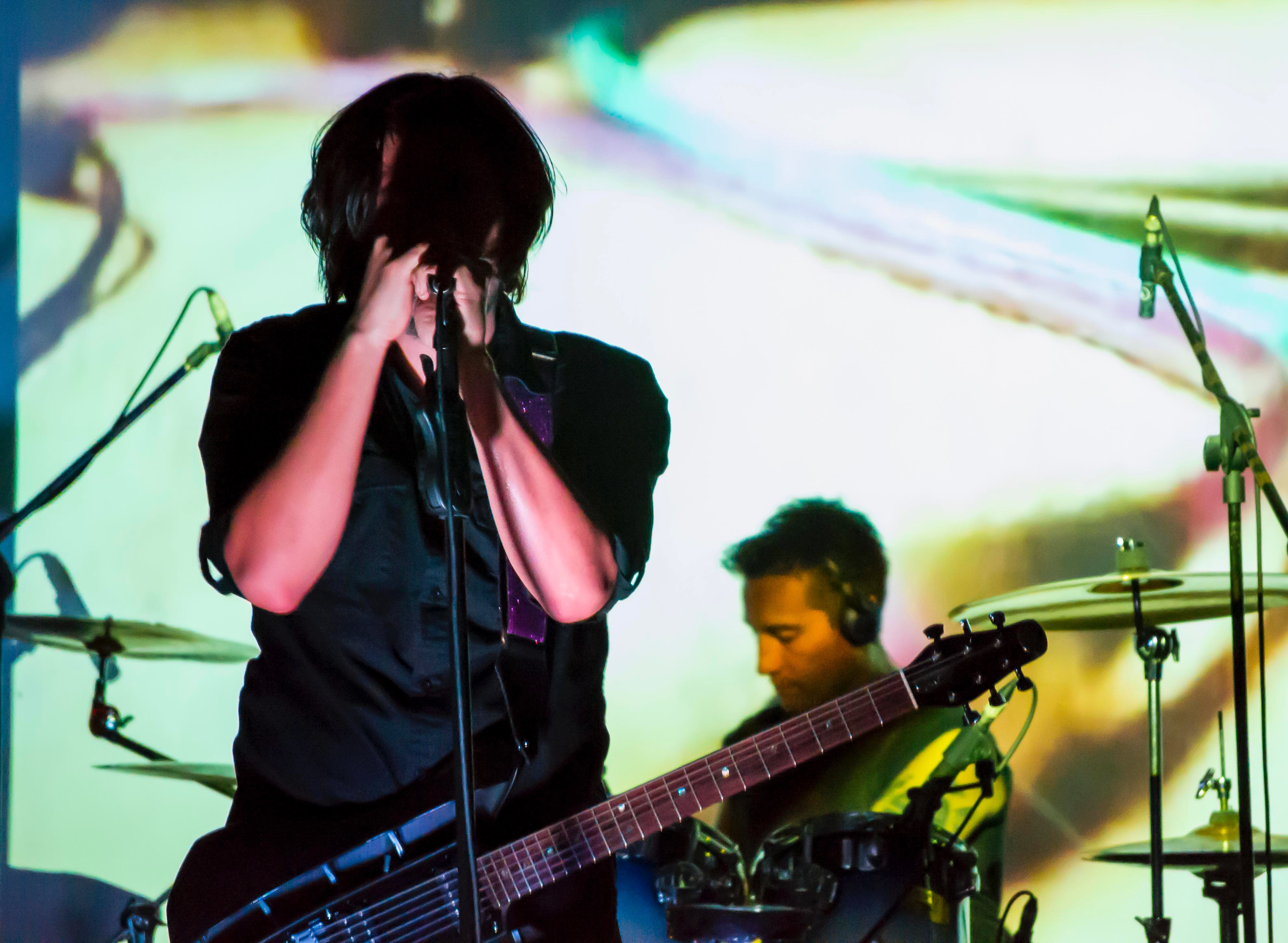 a man on stage with a guitar and microphone