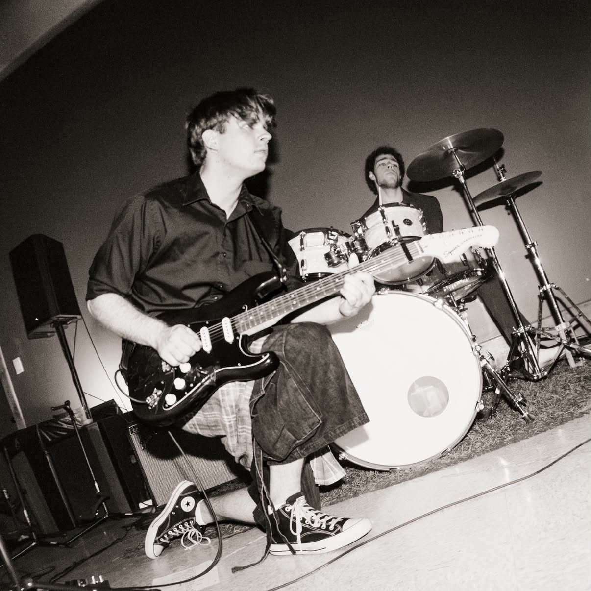 a black and white photo of a man playing a guitar