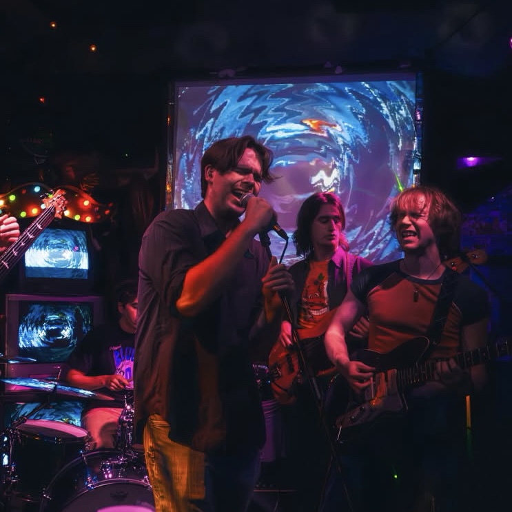 a group of people playing music in a dark room