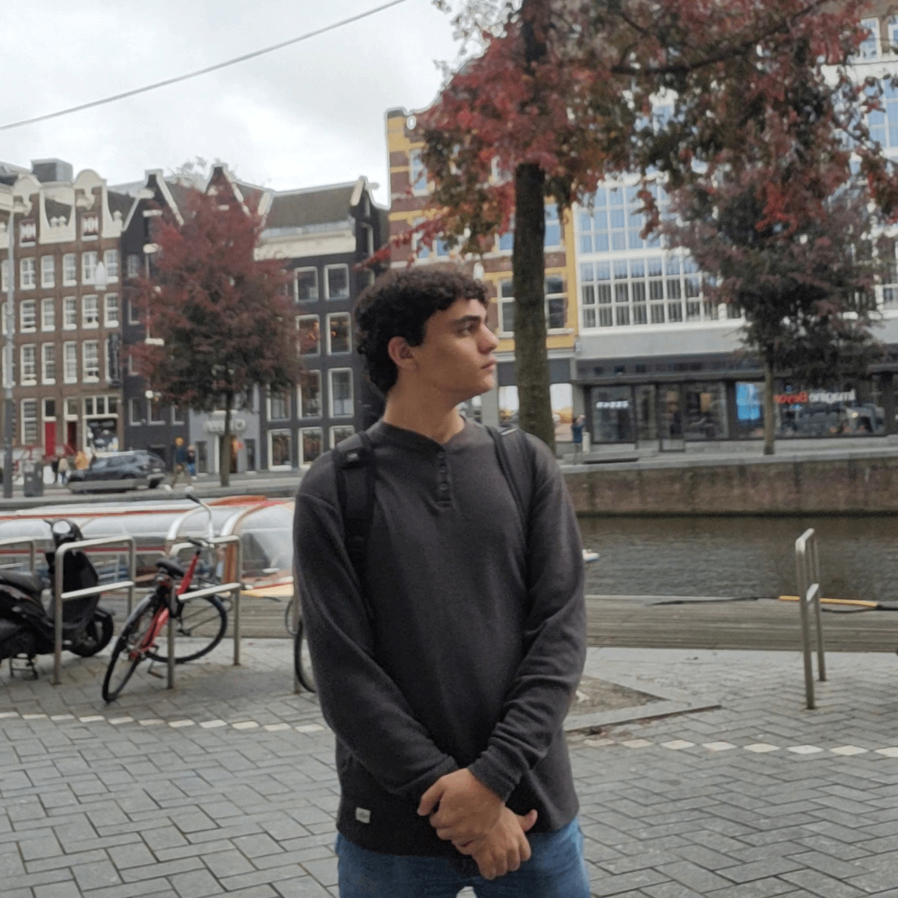 a man standing on a sidewalk near a canal