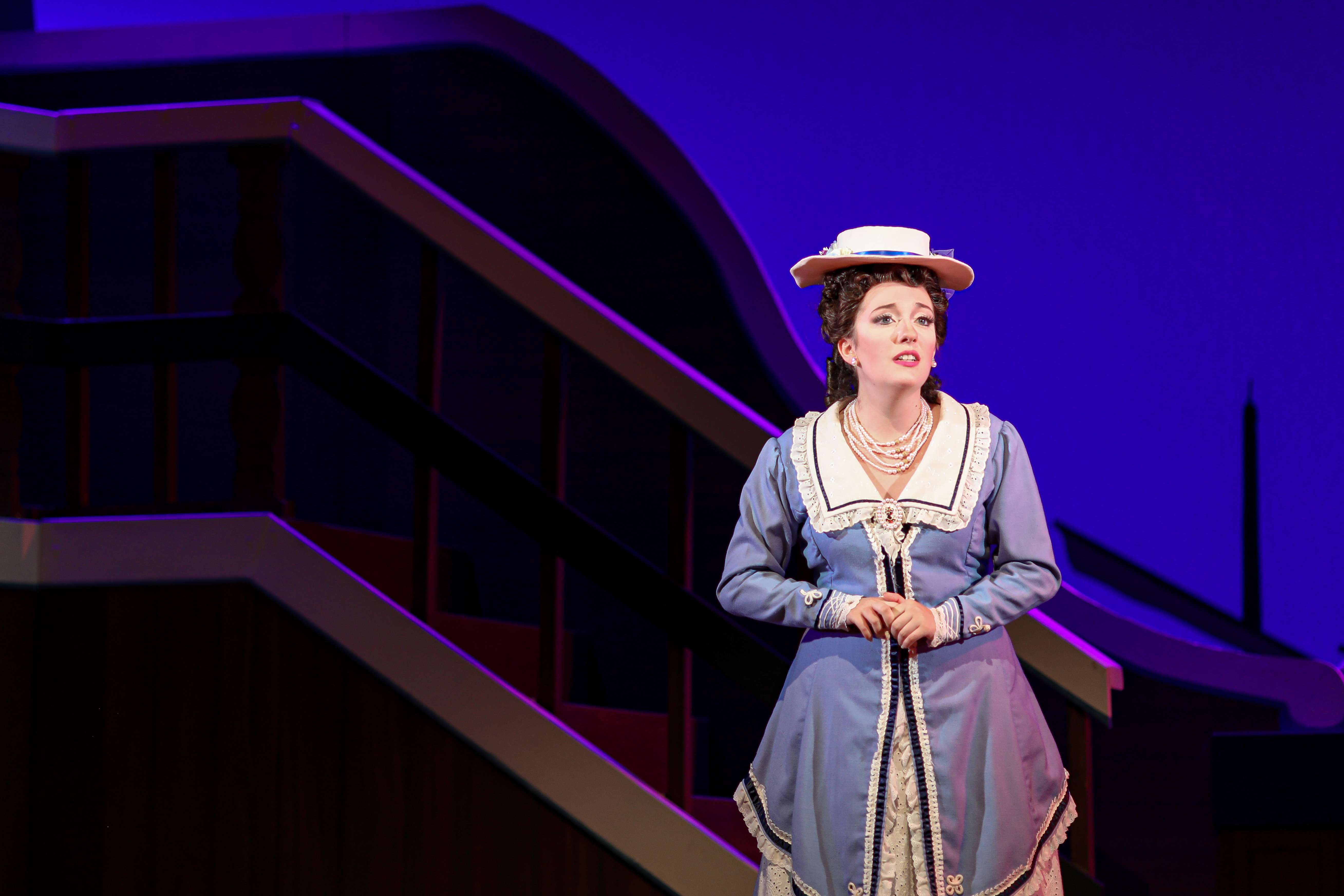 a woman in a blue dress standing on a stage