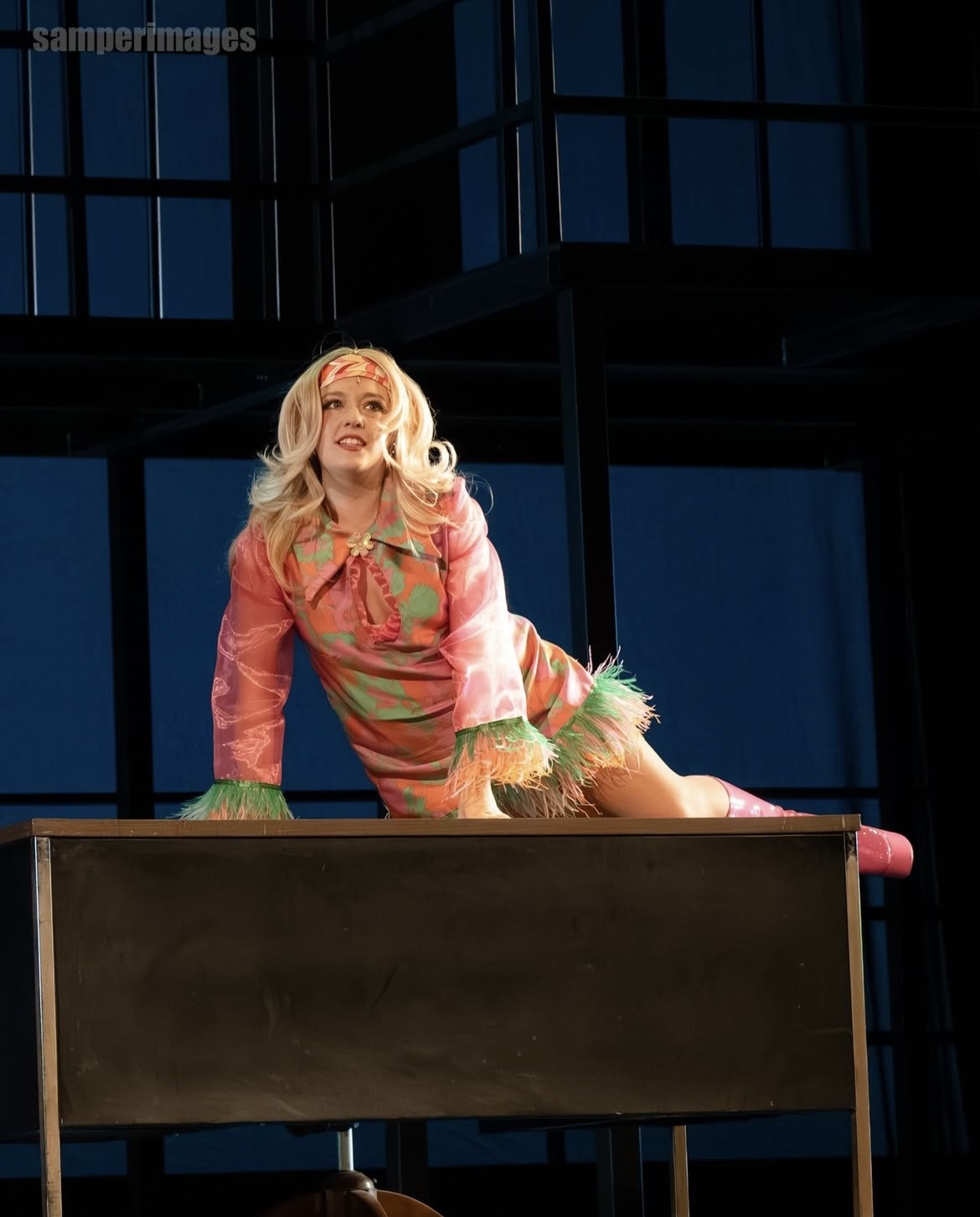 a woman in a pink dress laying on top of a table