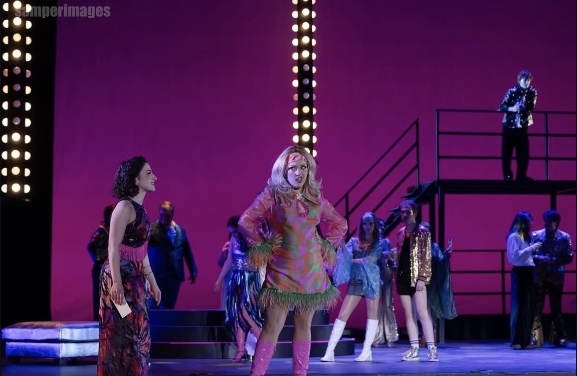 a woman in a pink dress is standing on a stage