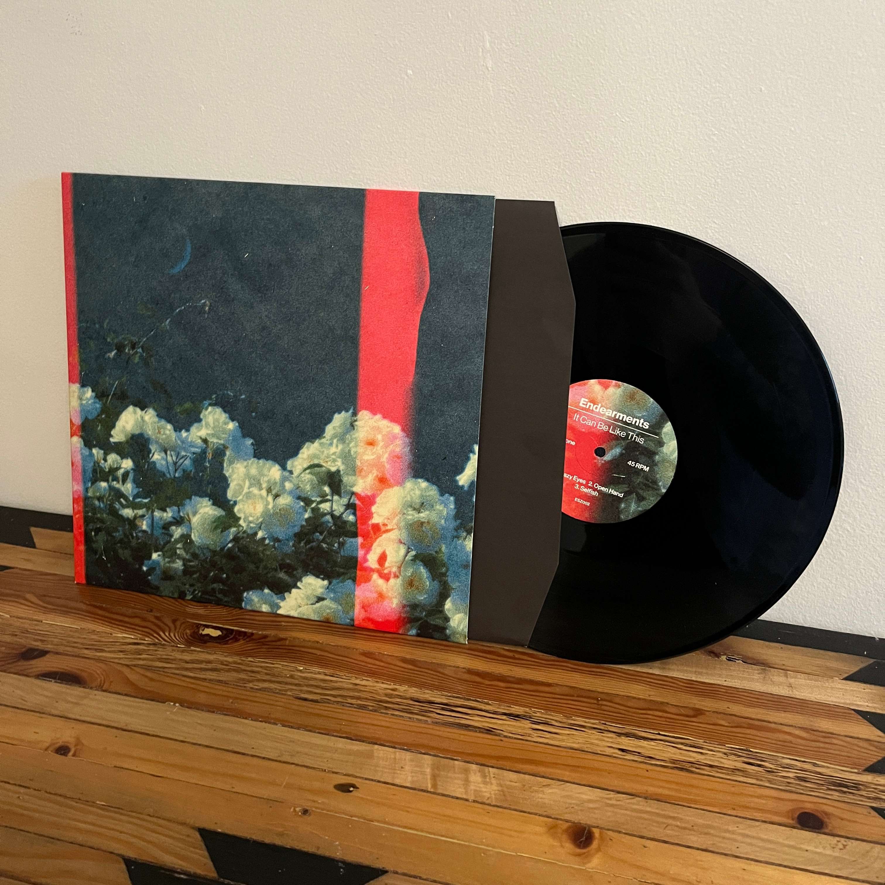 a black and red lp on a wooden table