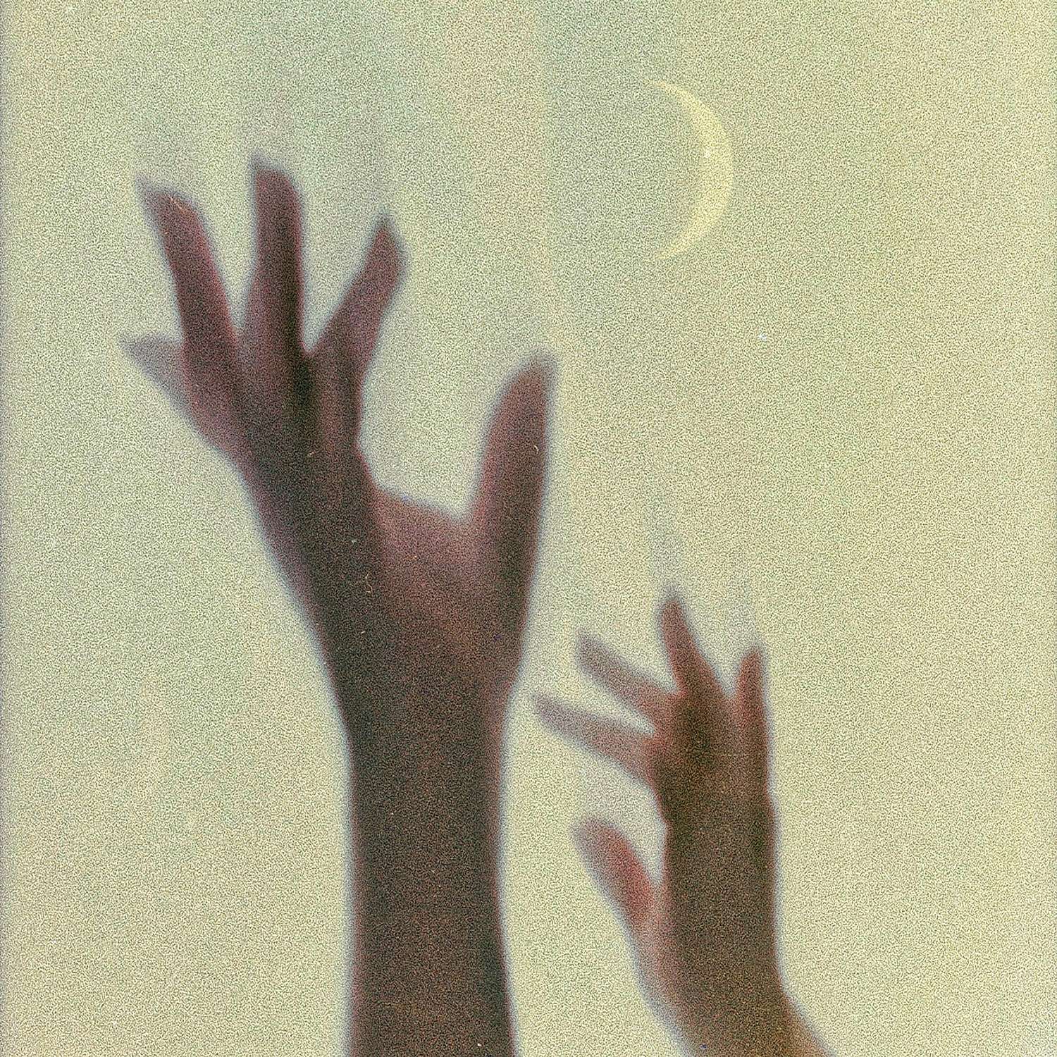 a person's hands reaching for the moon
