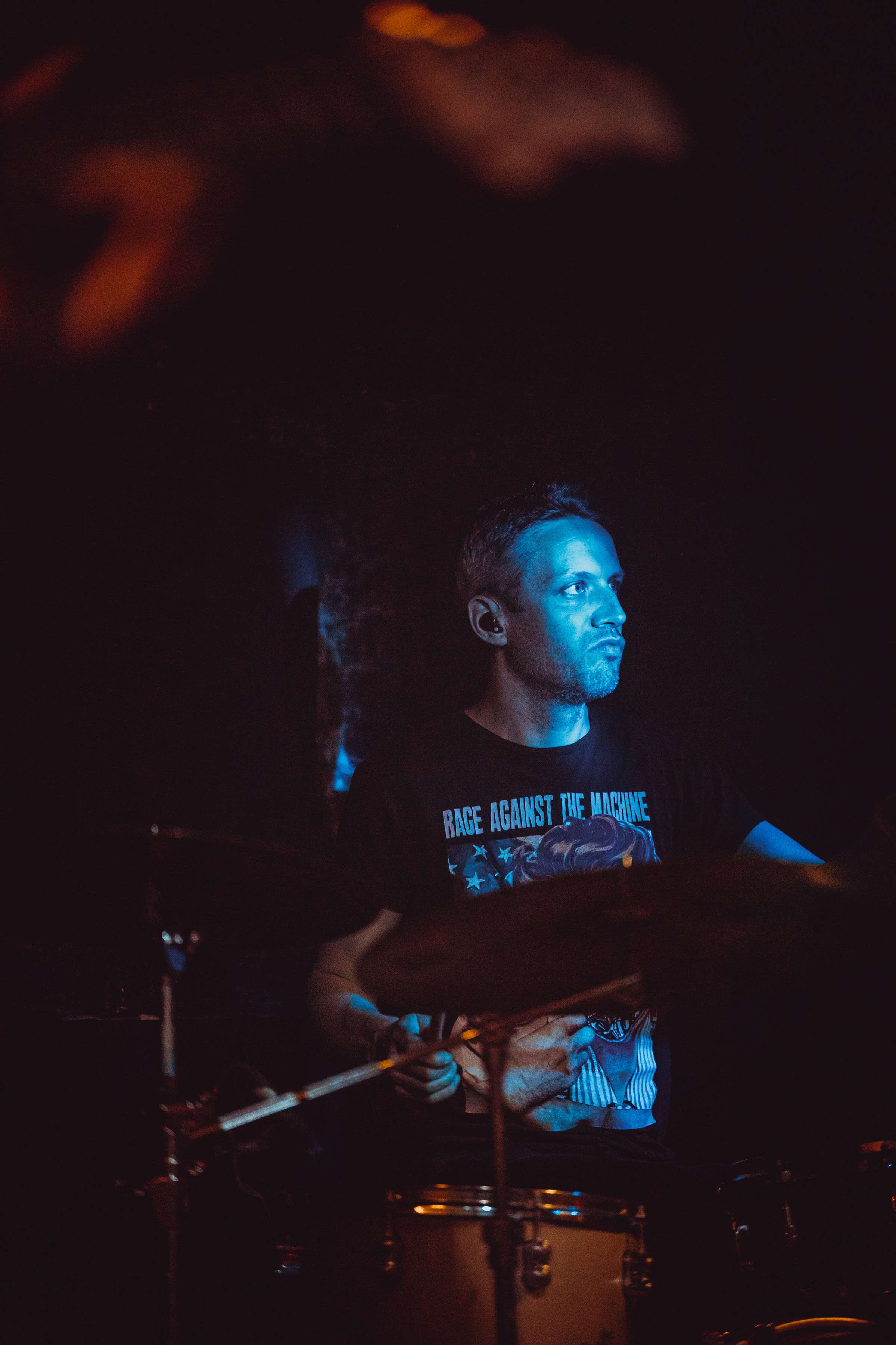 a man playing drums in a dark room